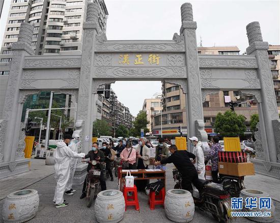  4月16日，進(jìn)出武漢漢正街步行街的人員在掃描健康碼。新華社記者 王毓國 攝